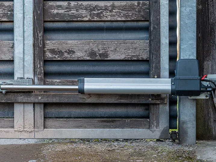 Professional technician performing Gate Operator Maintenance for a residential driveway gate.